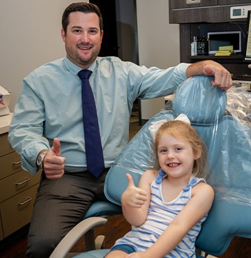 Doctor Palmer and child in dental chair giving thumbs up in Houston dental office