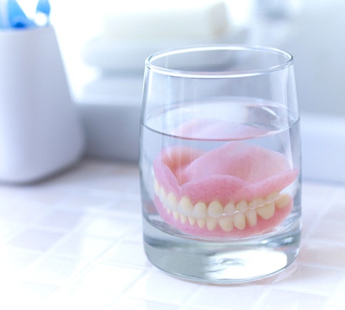 Dentures soaking in glass of water