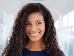 Teenage girl with curly dark hair smiling