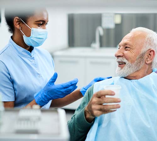 Older woman smiling while visiting an implant dentist in Houston