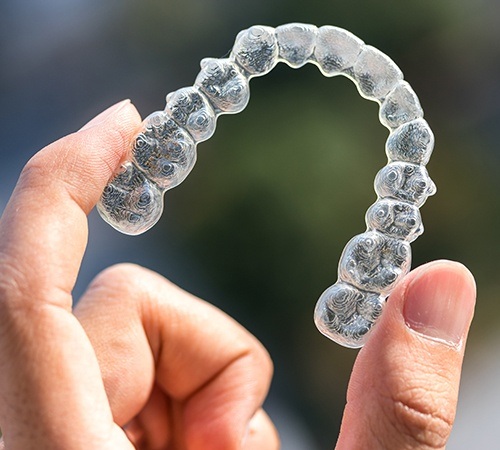 Patient holding an Invisalign alignment tray