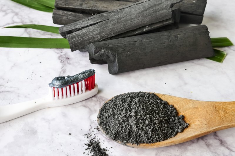 Activated charcoal lying next to toothbrush on table