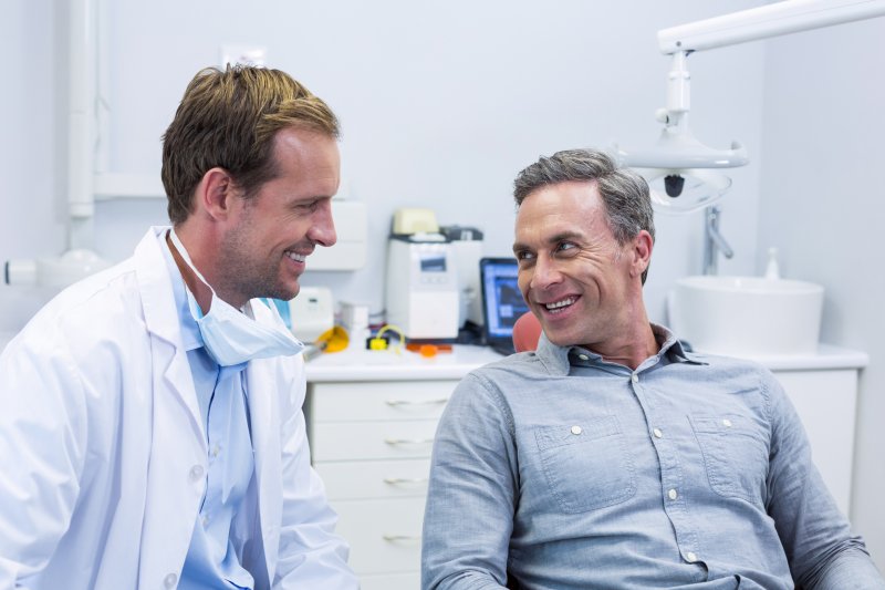 patient speaking to dentist at dental implant consultation